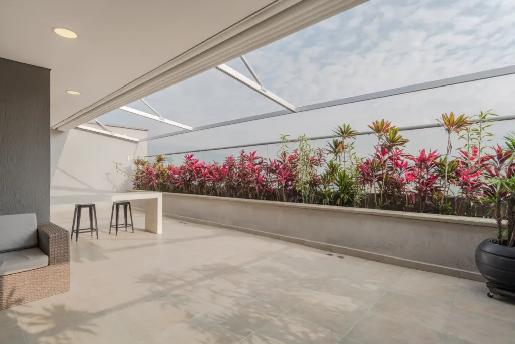 Pérgola retráctil PergoTek sobre la barra y la jardinera de la terraza del edificio Avani