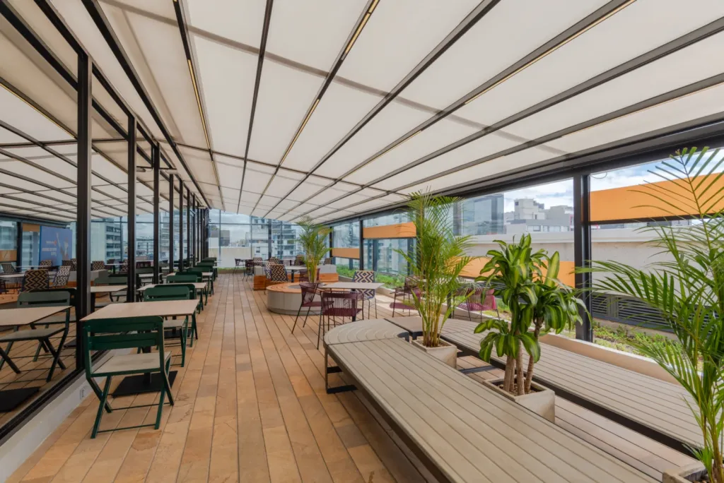 Pérgola retráctil PergoTek sobre el comedor de la terraza de La Roche, con las montañas al fondo