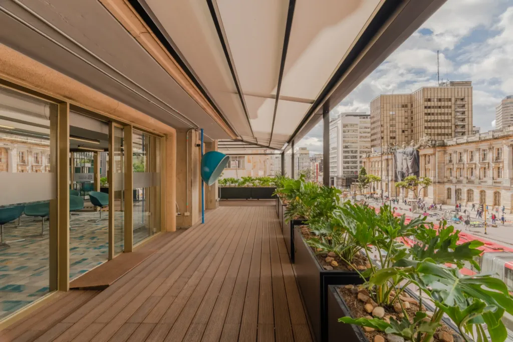 Corredor de deck bajo la pérgola retráctil PergoTek junto a la fachada del Edificio El Tiempo en Bogotá