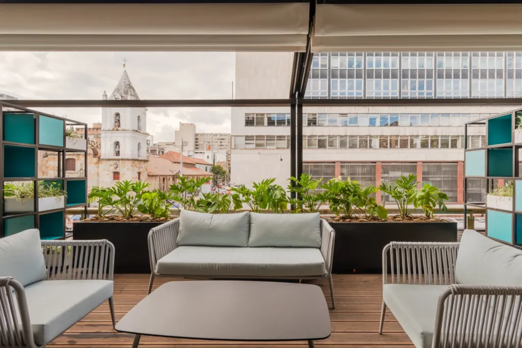 Sala exterior bajo la pérgola PergoTek abierta en la terraza del Edificio El Tiempo en Bogotá