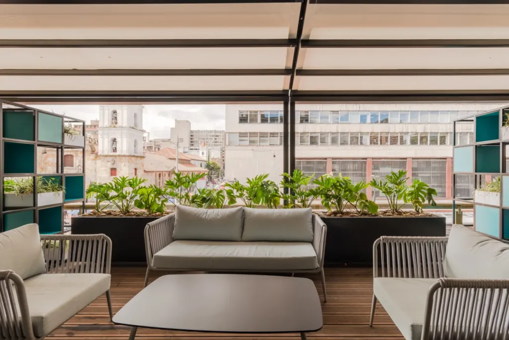 Sala exterior con la pérgola retráctil PergoTek cerrada en la terraza del Edificio El Tiempo en Bogotá