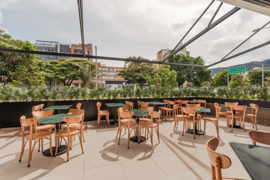 Pérgola retráctil PergoTek sobre la terraza de mesas de un restaurante El Corral