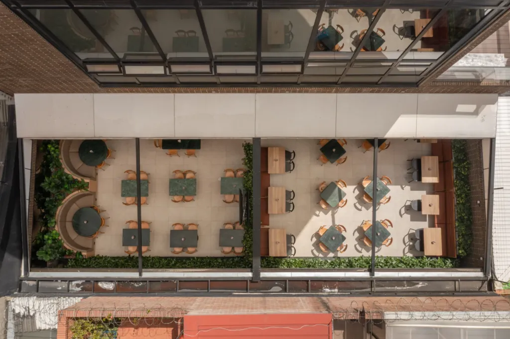 Vista cenital de la terraza de un restaurante El Corral cubierta con pérgola retráctil PergoTek
