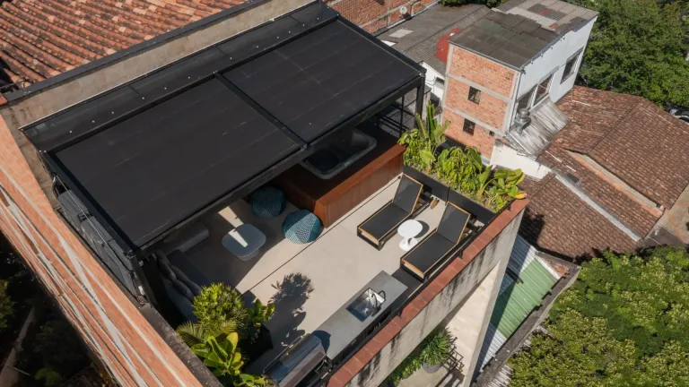 Vista aérea de la pérgola retráctil cerrada con paneles oscuros sobre la terraza del ático del Edificio Atico II