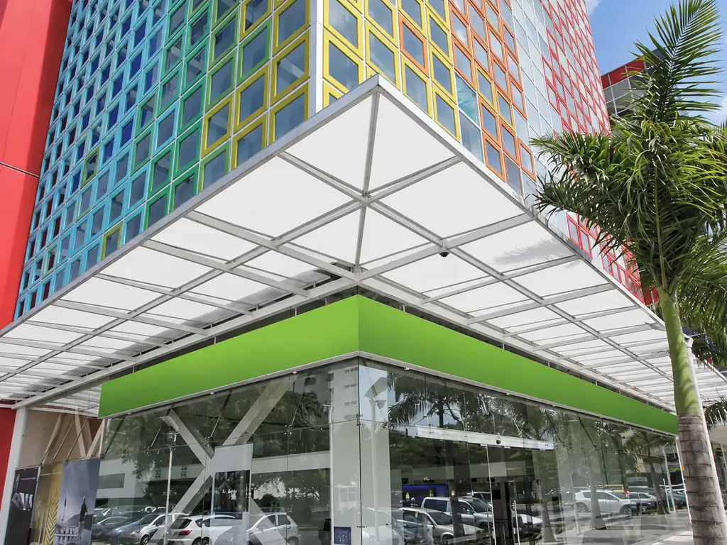Cubierta fija de policarbonato con estructura en aluminio sobre la esquina de un edificio