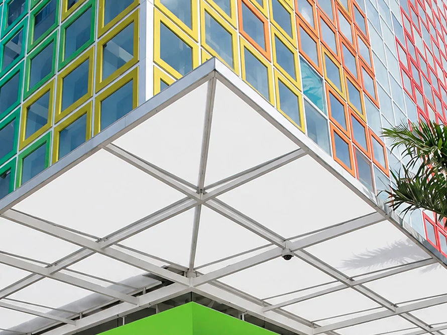Estructura en aluminio y policarbonato de una cubierta fija sobre el acceso de un edificio