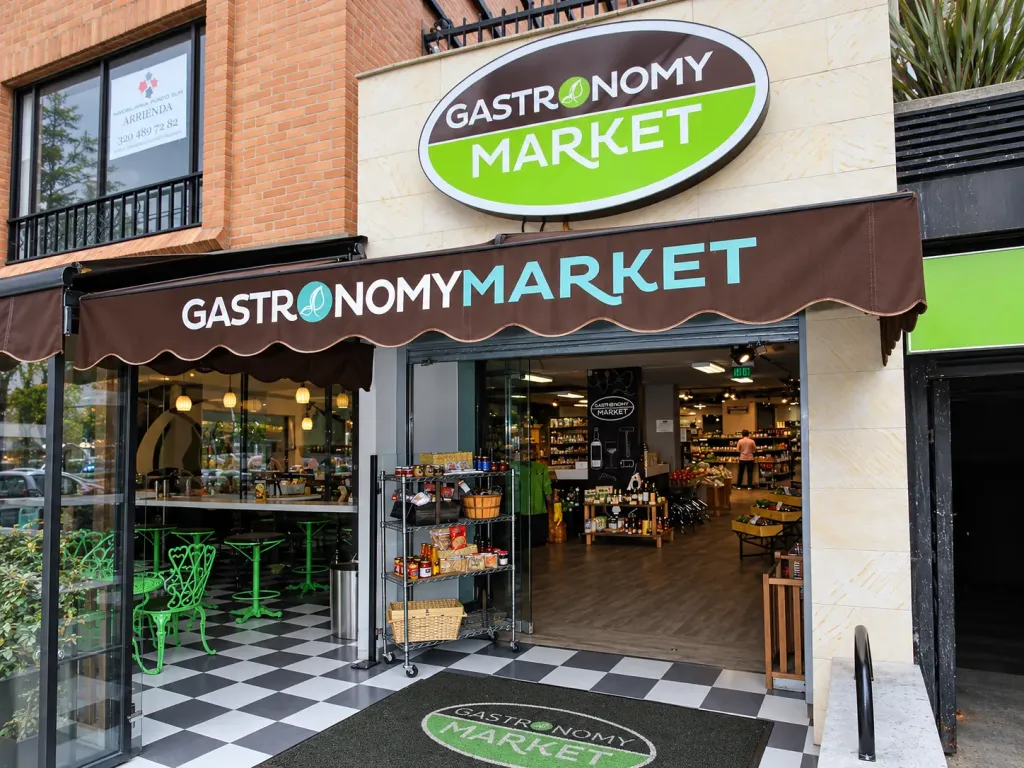 Toldo fijo Corbella sobre la entrada de un mercado gourmet