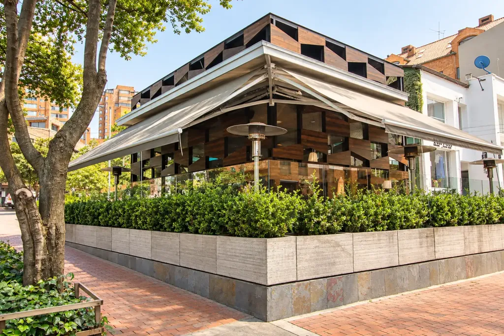 Toldos retráctiles a dos frentes en la esquina de Creppes & Waffles, sobre la terraza acristalada