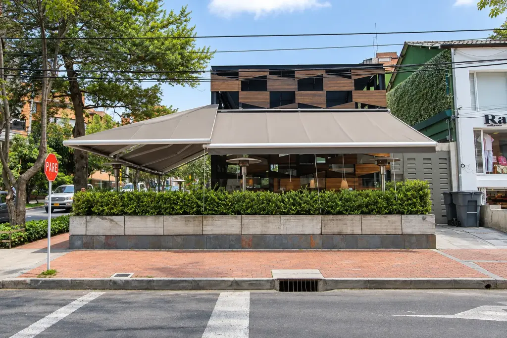 Fachada frontal de Creppes & Waffles con el toldo retráctil desplegado sobre la terraza